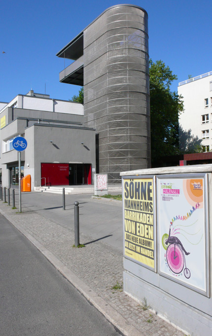 Foto eines von okamo aus Berlin gestalteten Plakats im Stadtraum. Das Plakat dient der gesamtstädtischen Öffentlichkeitsarbeit eines der drei Preisträger der Zentren-Initiative MittendrIn Berlin! 2010/11. Im Hintergrund ist die Mauergedenkstätte in der Bernauer Straße zu sehen.